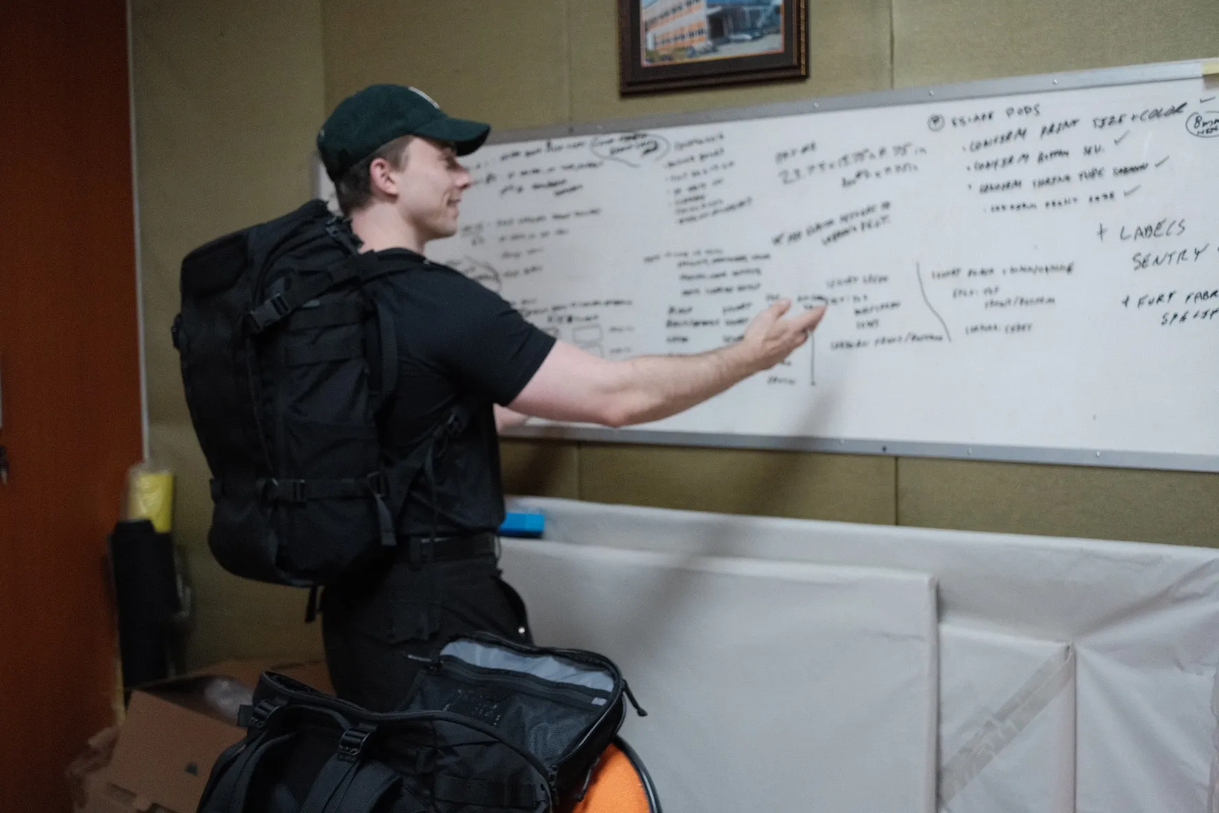 Michael at a whiteboard of production specs in the factory office