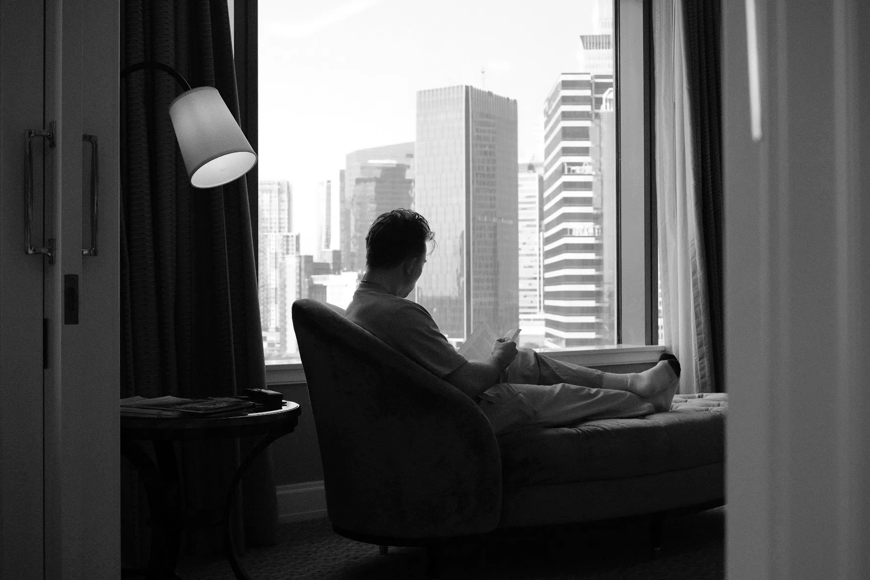 Michael in a chair by a window over the city